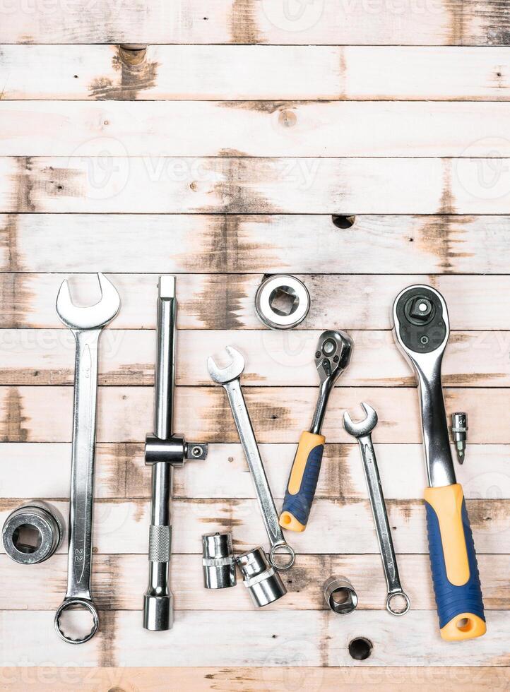 Collection of metal hand tools arranged on a wooden surface with a rustic feel photo