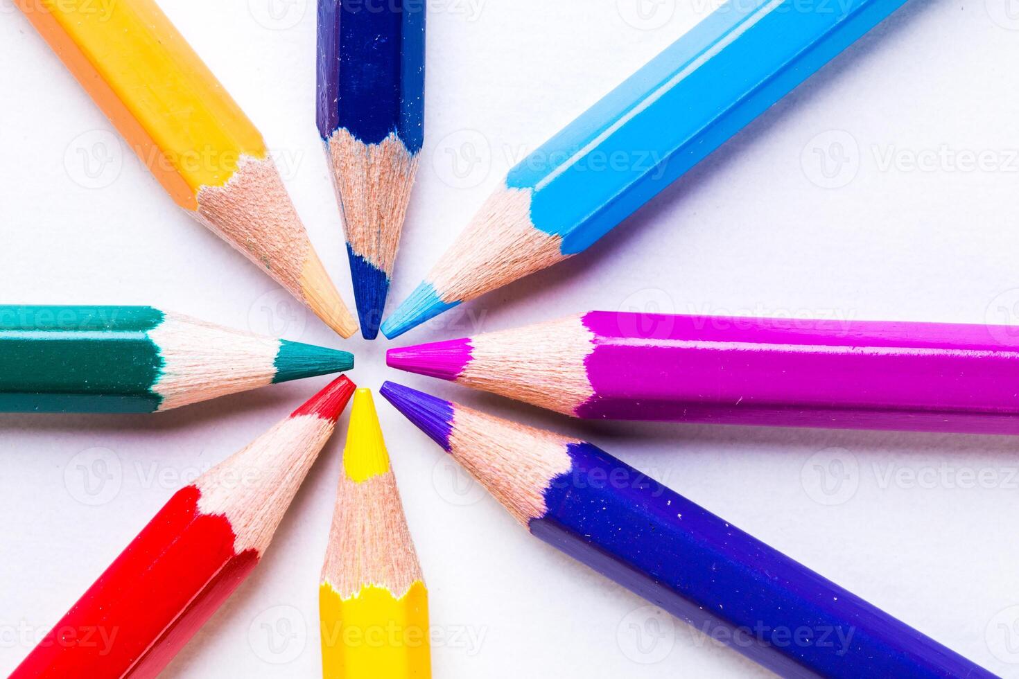 Colorful arrangement of sharpened pencils radiating from the center on a white background photo