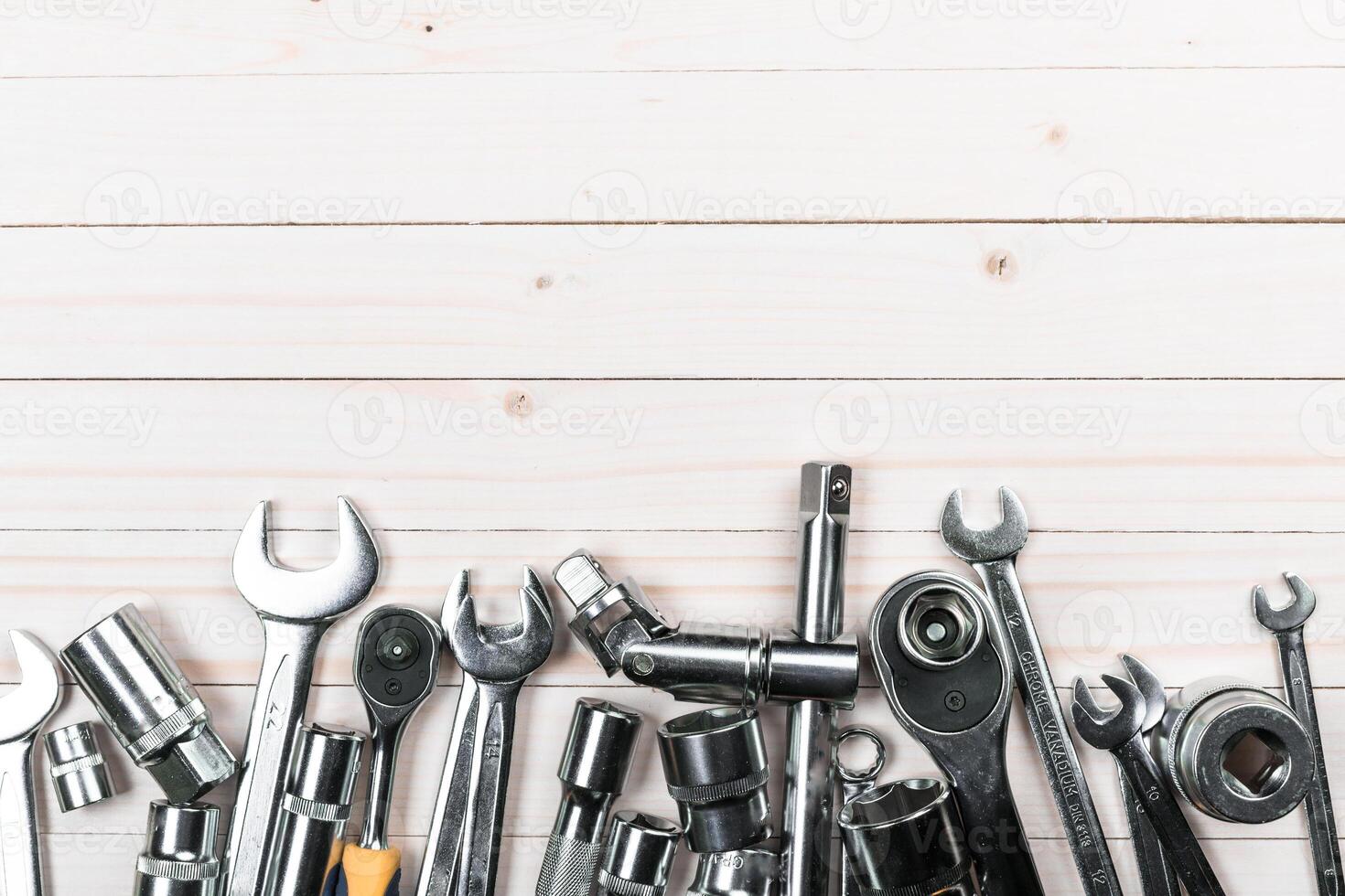 Collection of metallic tools arranged on a wooden surface ready for mechanical projects and repairs photo