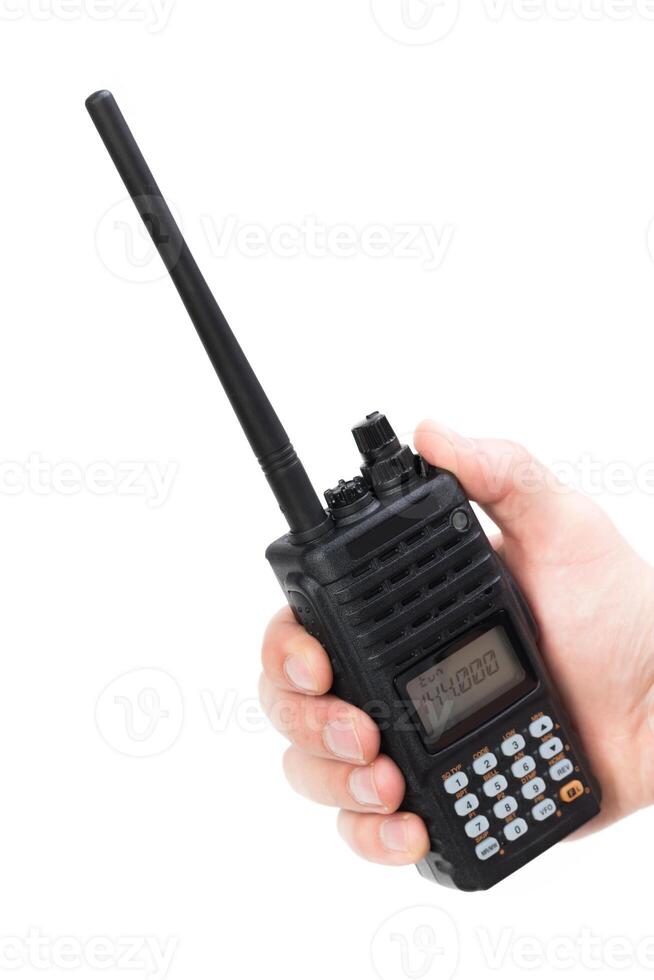 Handheld walkie-talkie with extended antenna held by individual in bright lighting conditions photo