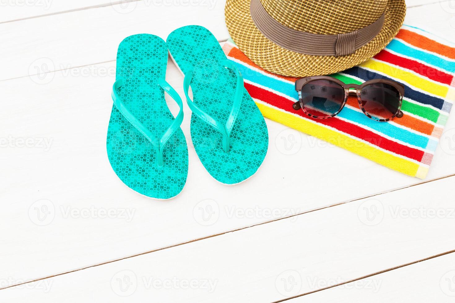 Bright flip flops, stylish hat, and sunglasses on a colorful beach towel ready for a day in the sun photo