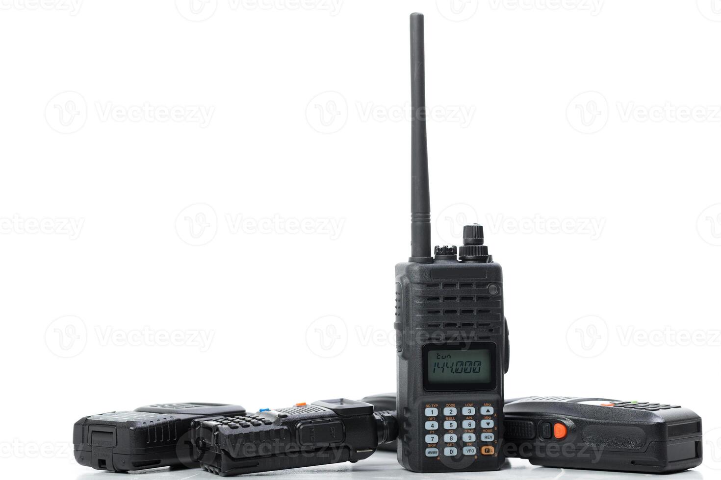 Collection of handheld radios displayed on a white background for communication purposes and emergency use in various situations photo