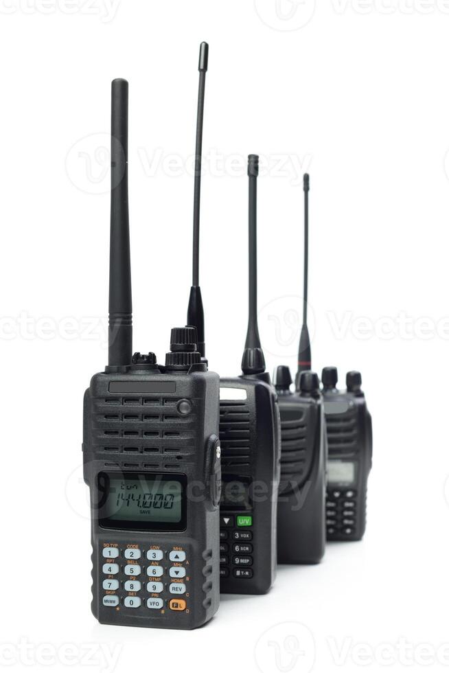 Multiple handheld two-way radios arranged in a row with distinct antennas and displays for communication purposes photo