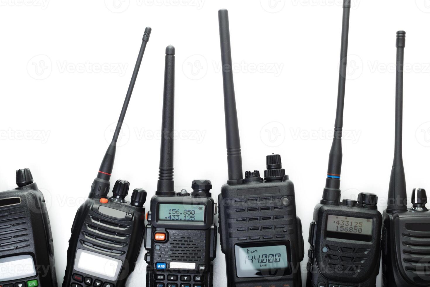 Various handheld radios displayed on white background for communication technology enthusiasts photo