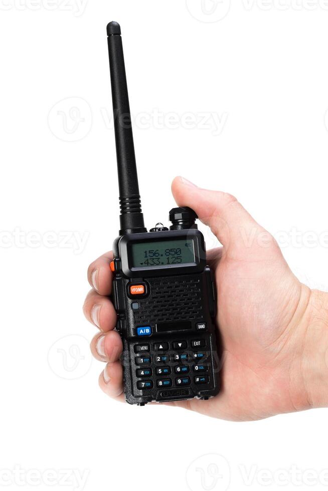 Handheld two-way radio being held for communication in a clear setting photo