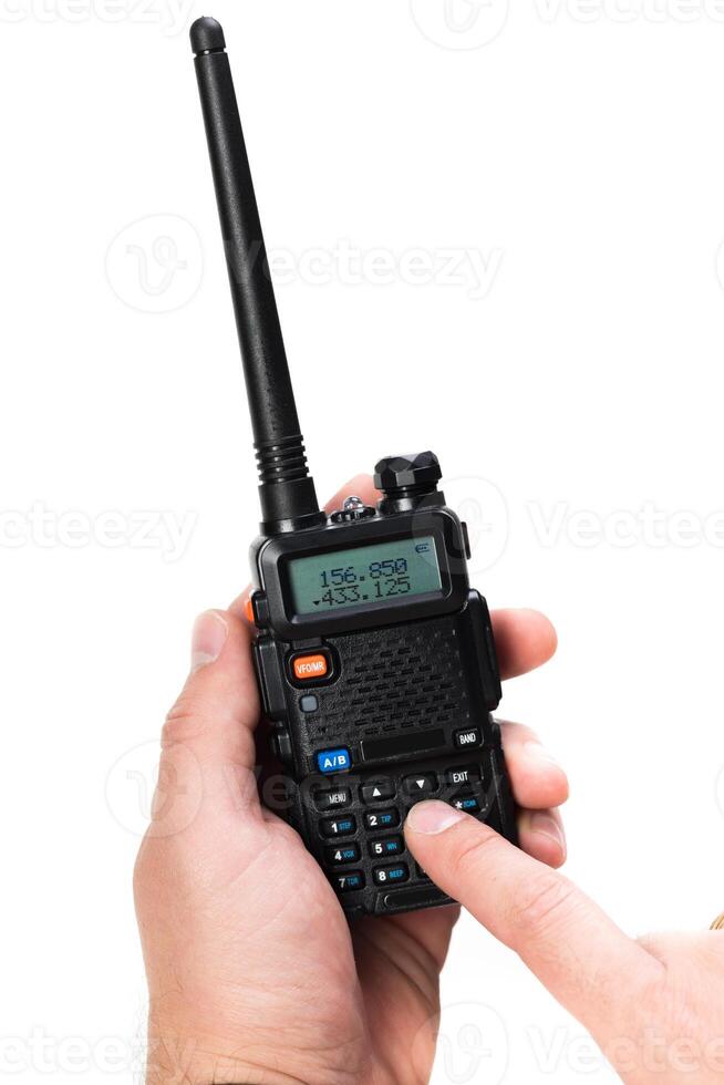 Handheld two-way radio with visible frequency display being operated indoors photo