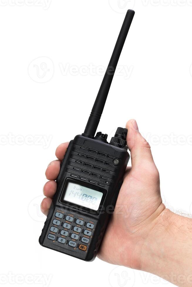 Handheld two-way radio being held in a person's hand for communication outdoors photo