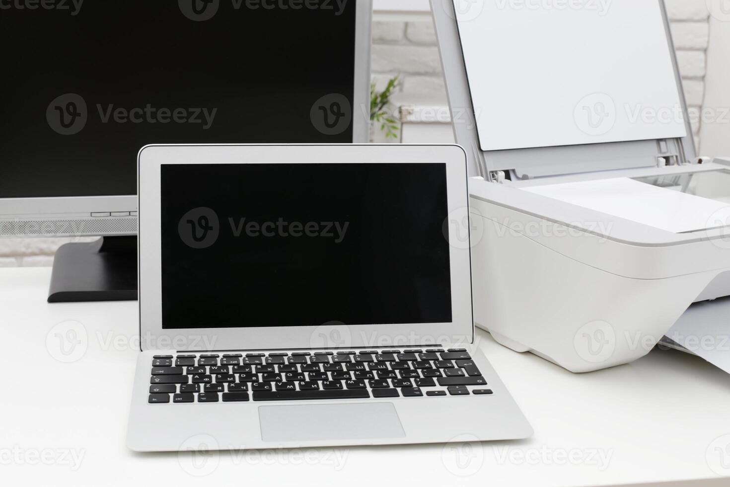 Workspace setup featuring a laptop and printer in a modern office environment photo