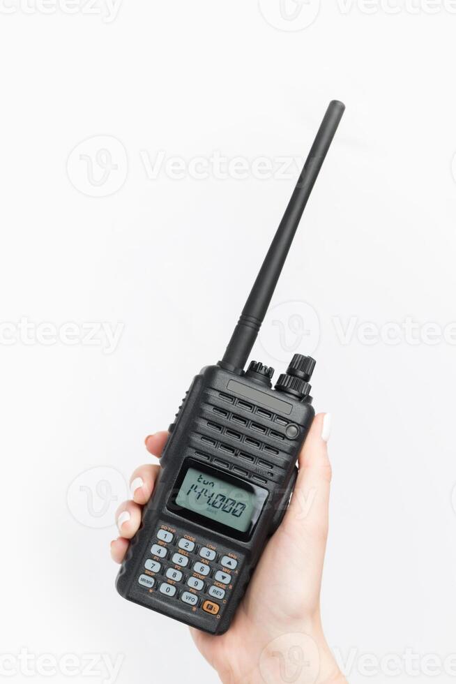 Handheld two-way radio being held with a clear display and antenna during a communication session photo