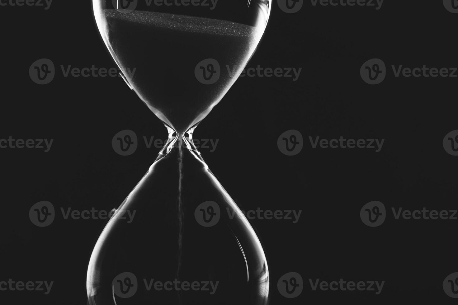 Sand flows steadily in an hourglass creating a captivating visual of time's passage photo