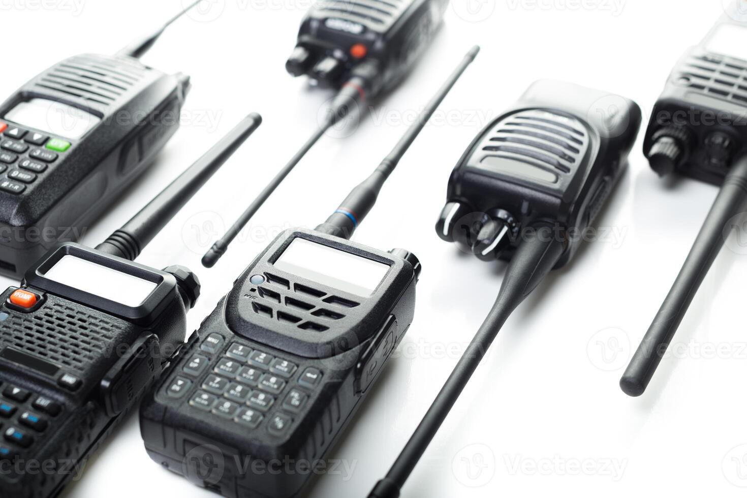 Various models of walkie talkies arranged on a white surface for technology showcase in communication devices photo