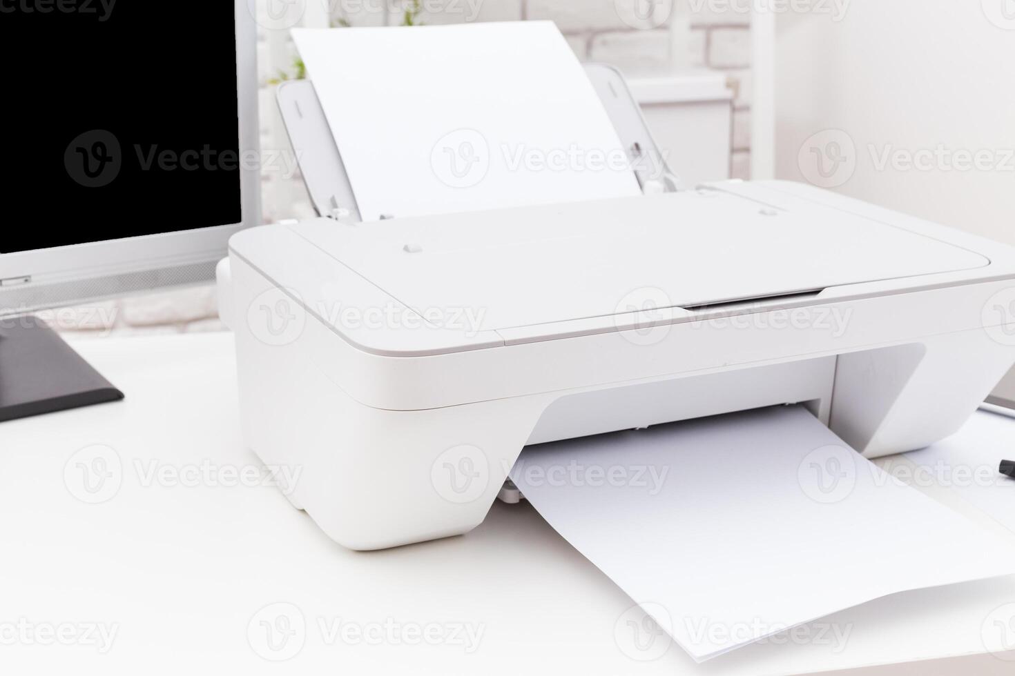 Printer on a desk with papers being printed in a modern office environment during daylight hours photo