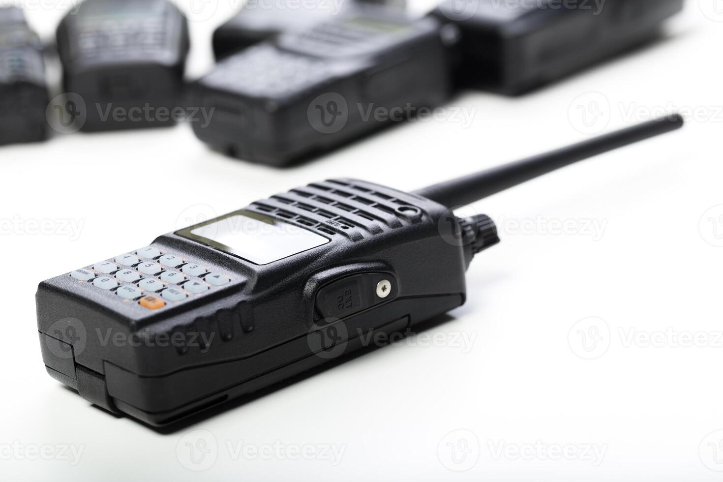 Black two-way radios arranged on a white surface for communication in professional settings and outdoor activities photo