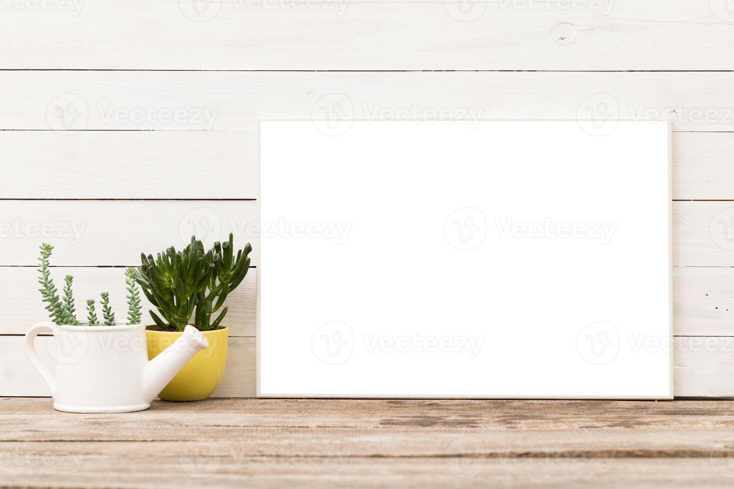 Blank canvas and potted plants on a wooden table in a bright indoor space captured during daylight photo
