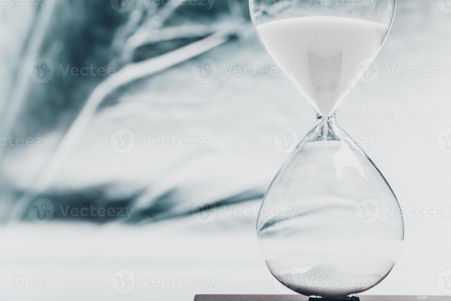 Elegant hourglass on a wooden surface with a blurred background highlighting the passage of time and moments in life photo