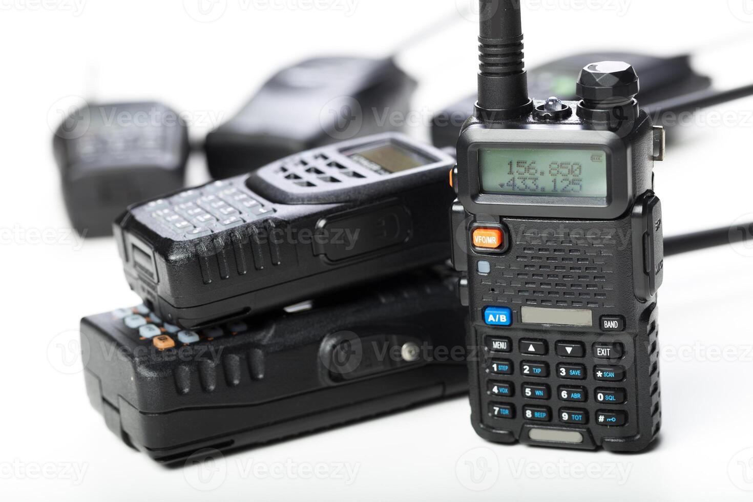 Various models of handheld radios stacked together for communication and emergency use photo