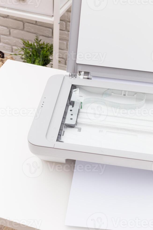 Scanner on a white table with blank paper ready for scanning in a bright indoor setting photo