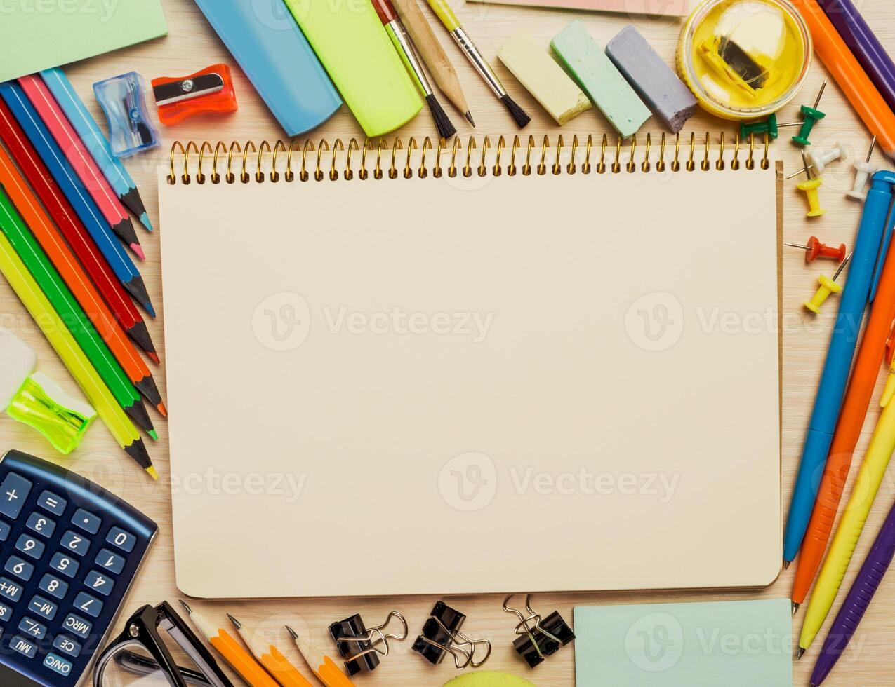 Study supplies and blank notepad arranged on a wooden table ready for creative work or assignments photo