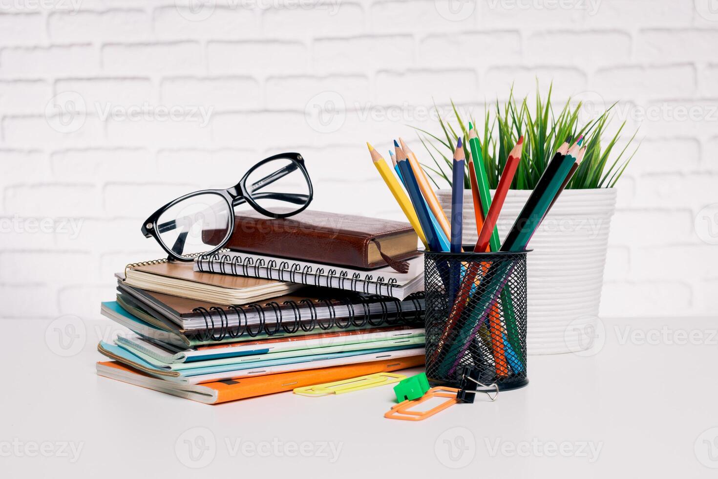 Desk setup with stationery supplies, notebooks, and glasses arranged in a neat workspace photo