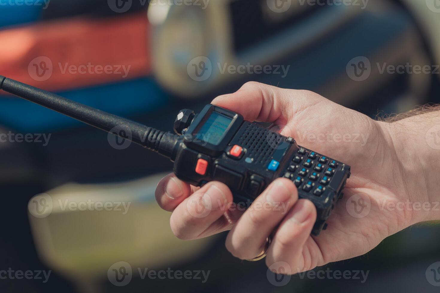 Communication device held in hand near a vehicle during daytime outdoor activity in a rural setting photo