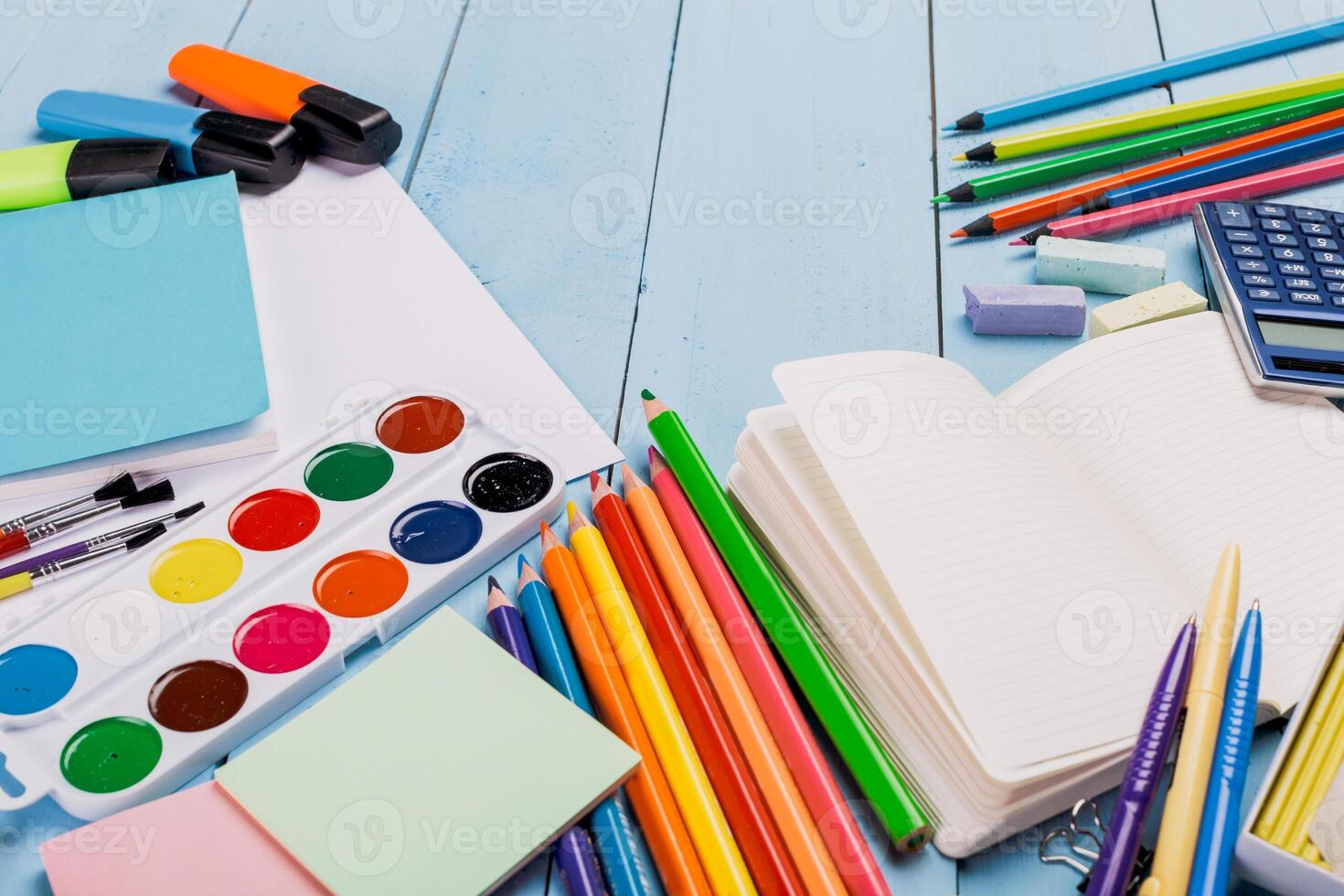 Colorful stationery and art supplies arranged on a light blue wooden surface for creative projects and study photo