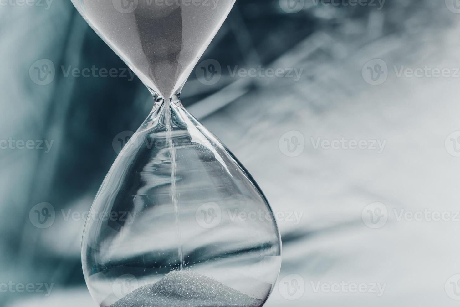 Time passing with an hourglass placed against a blurred background in soft tones photo