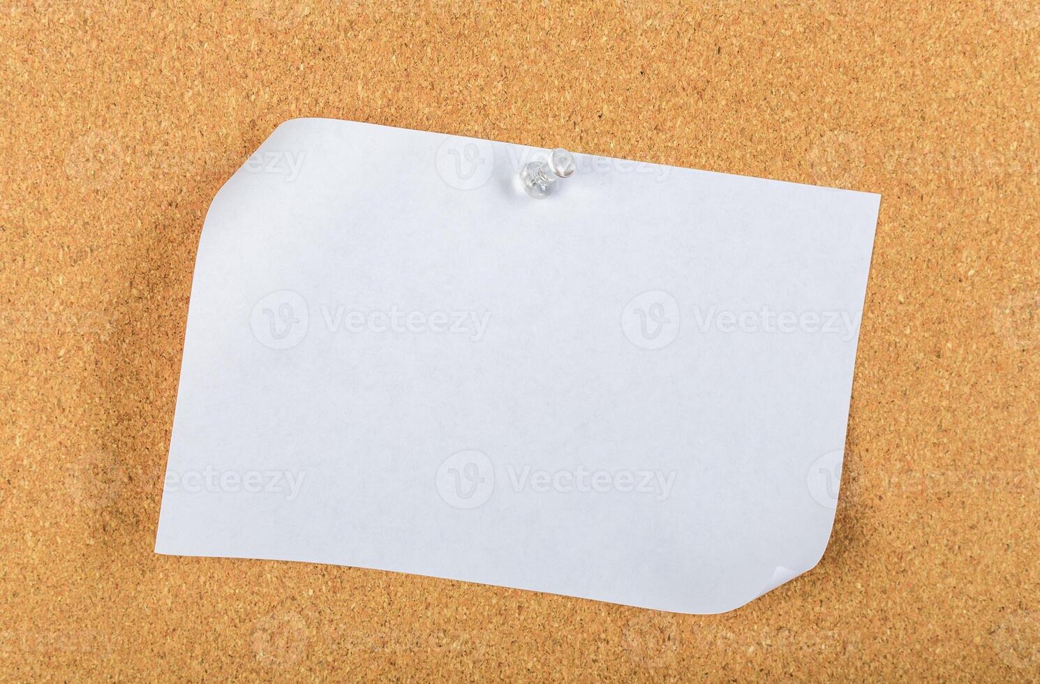 Blank sticky note pinned to a corkboard in an office setting during daylight hours photo