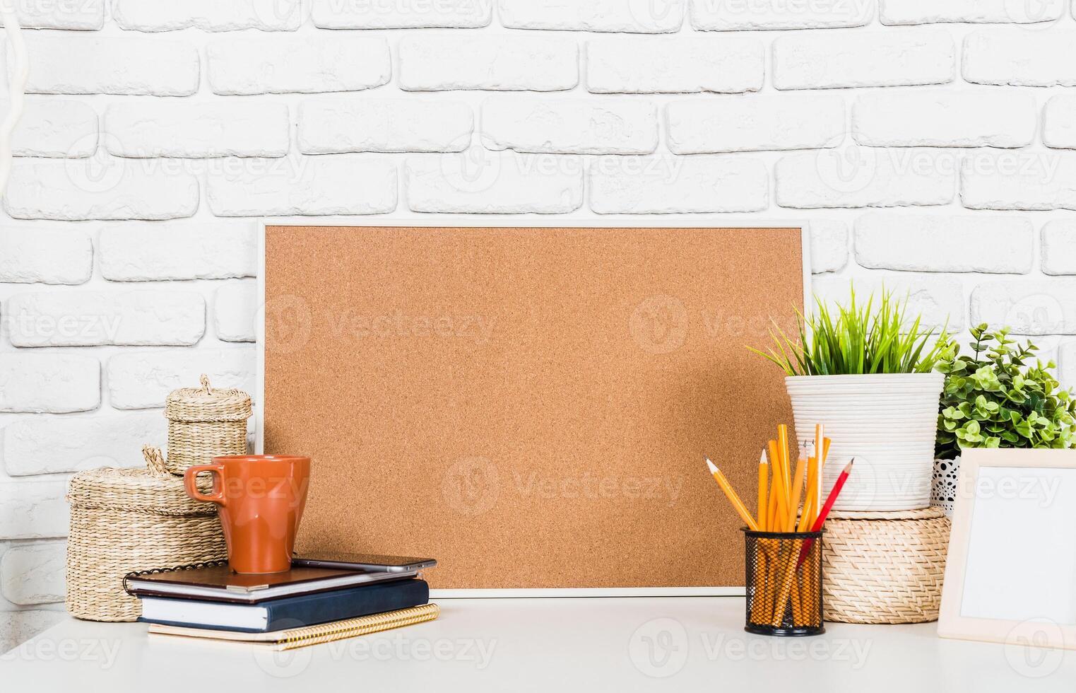 Creative workspace with cork board, notebooks, and potted plants in a bright, organized setting photo