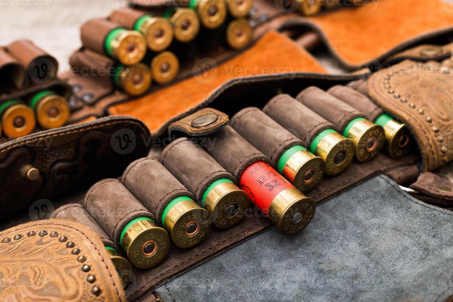 Leather ammunition holder with various shotgun shells arranged neatly on display during a shooting event in the countryside photo