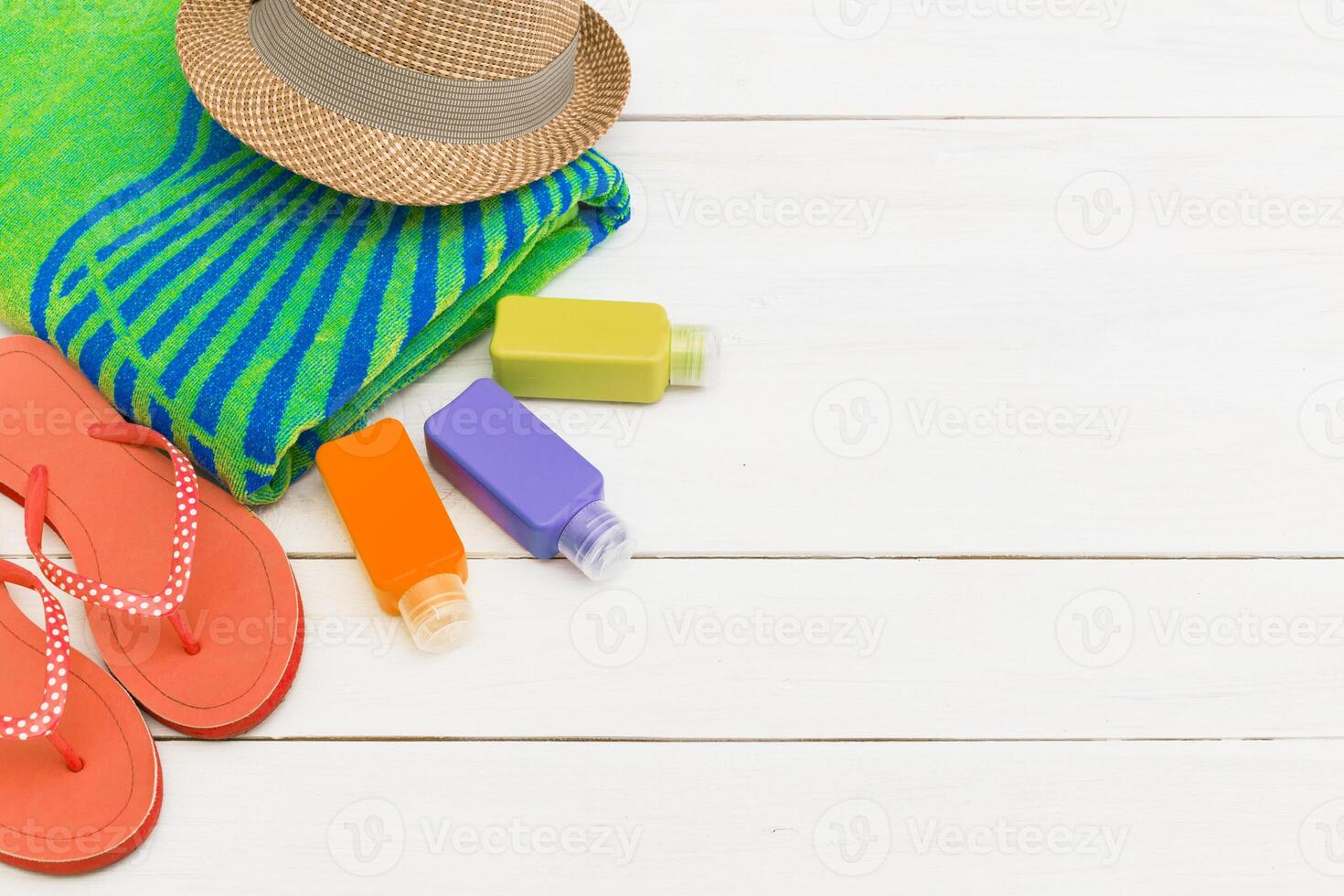 Beach day essentials with a colorful towel, flip flops, and sunscreen at a sunny location photo