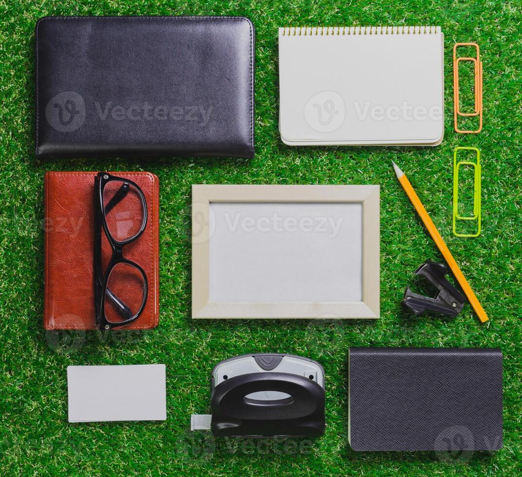 Office supplies arranged on green grass background creating a vibrant workspace scene photo