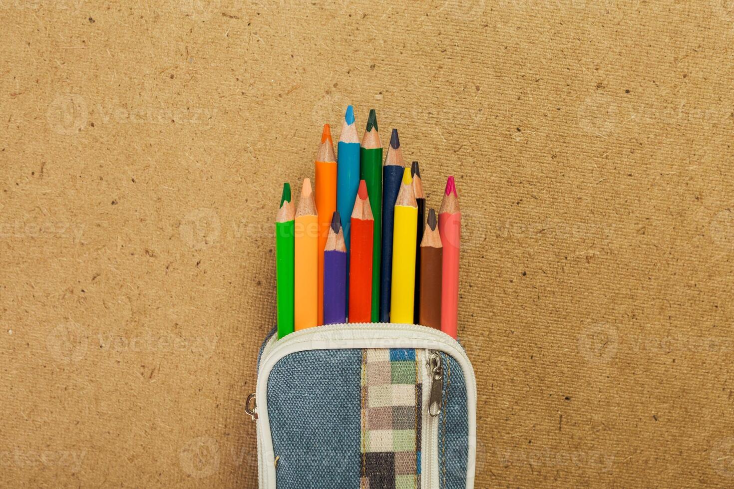 Colorful pencils neatly organized in a pencil case on a textured background photo