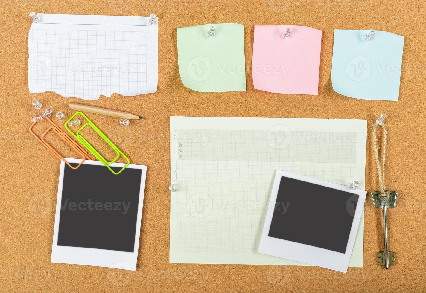 Bulletin board filled with blank notes, photos, and office supplies in a creative workspace environment photo