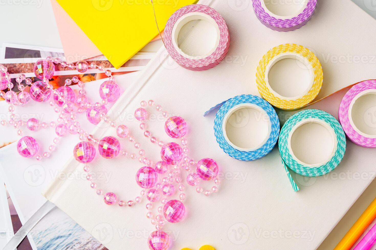 Colorful craft supplies including decorative tape and beads on a creative workspace in daylight photo