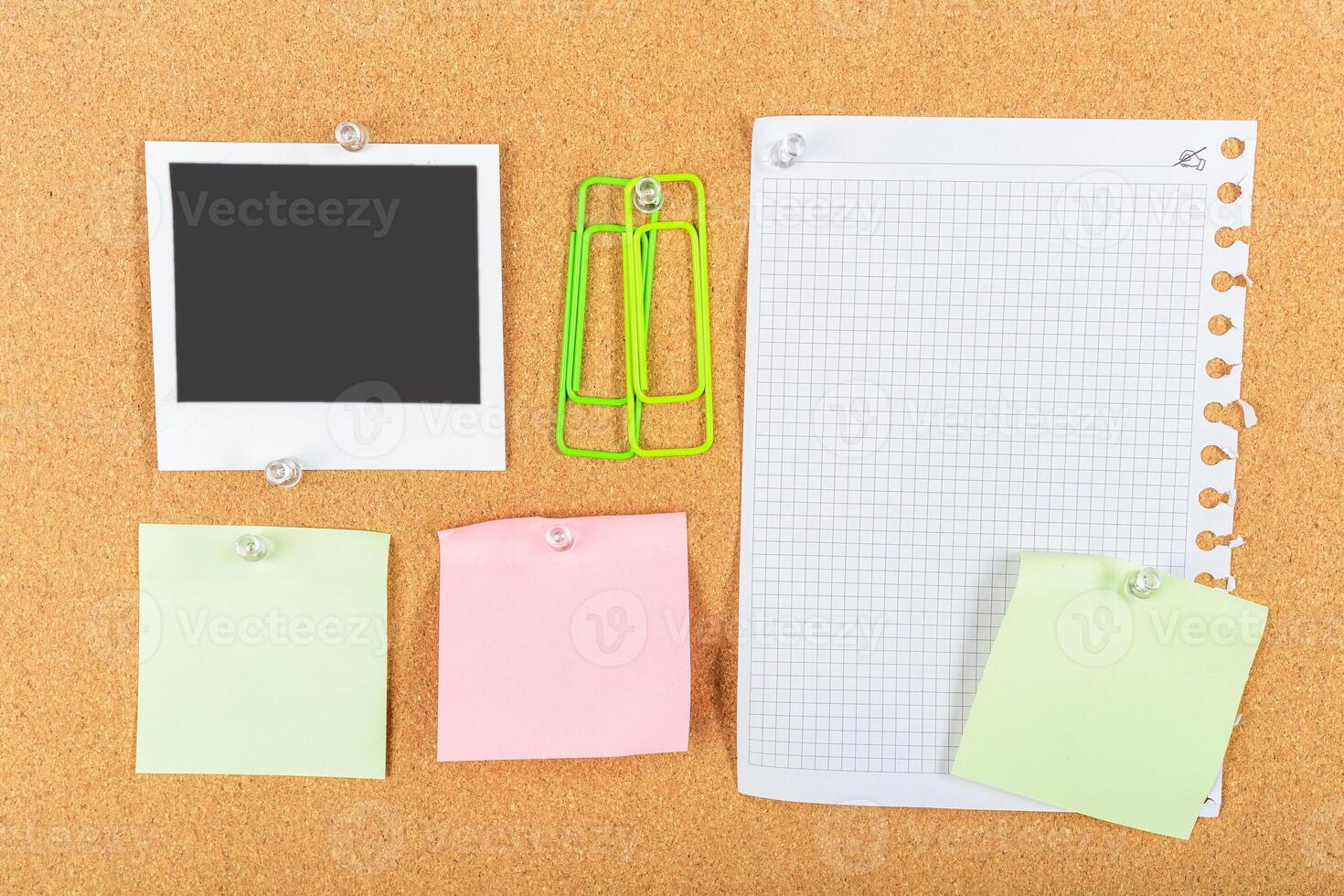 Notes, photos, and stationery arranged on a corkboard for planning and organization in a workspace photo