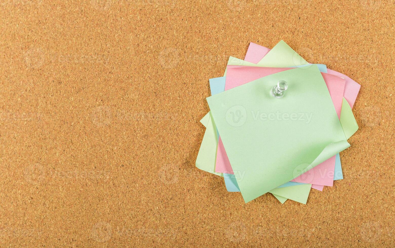 Colorful sticky notes arranged on a cork board for reminders and organization in an office setting photo