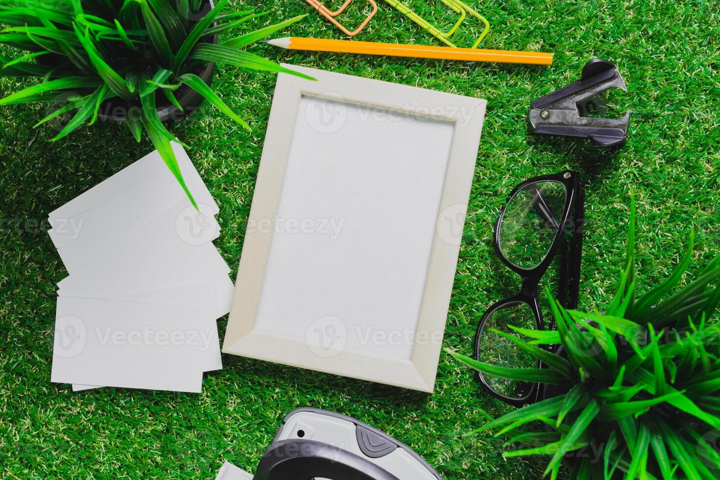 Exploring creativity with an empty frame, office supplies, and greenery on a vibrant workspace photo