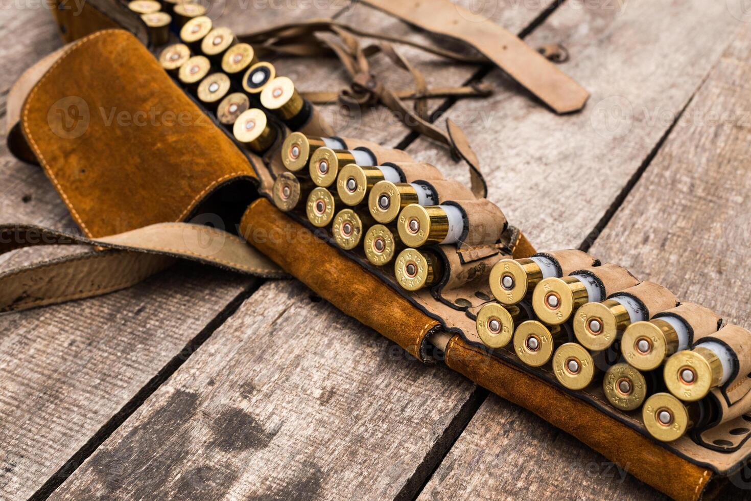 Vintage ammunition belt displayed on a rustic wooden surface highlighting craftsmanship and hunting culture photo