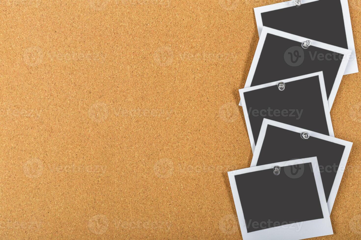 Creative workspace with blank photo frames pinned on corkboard for inspiration and ideas sharing