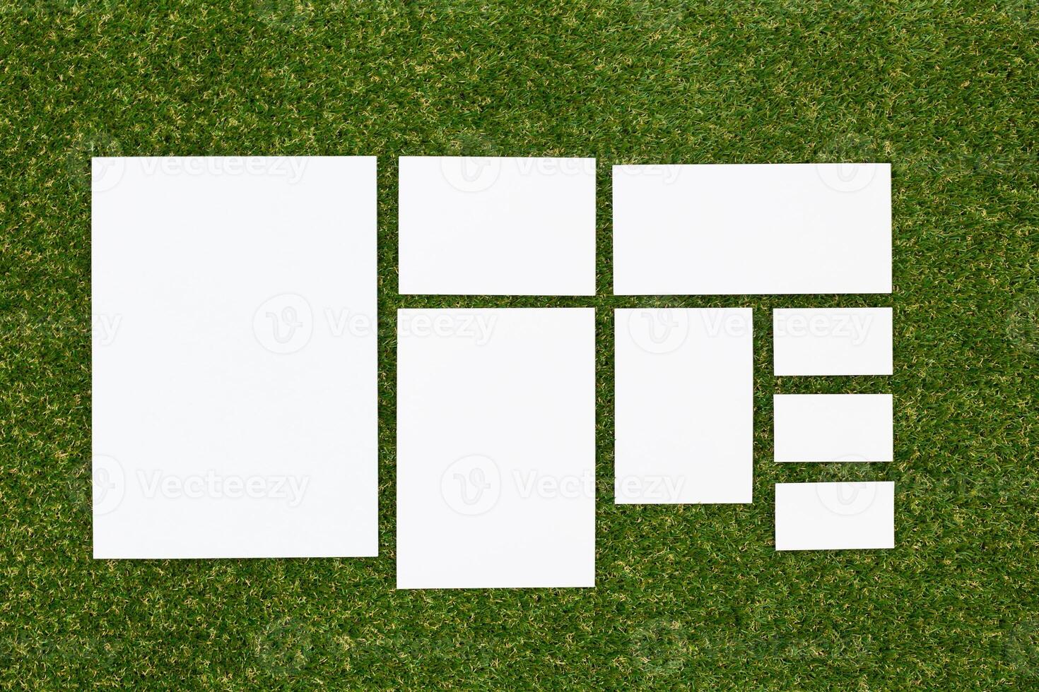 Multiple blank sheets arranged on grass for creative projects, design ideas, or presentations in a natural setting photo
