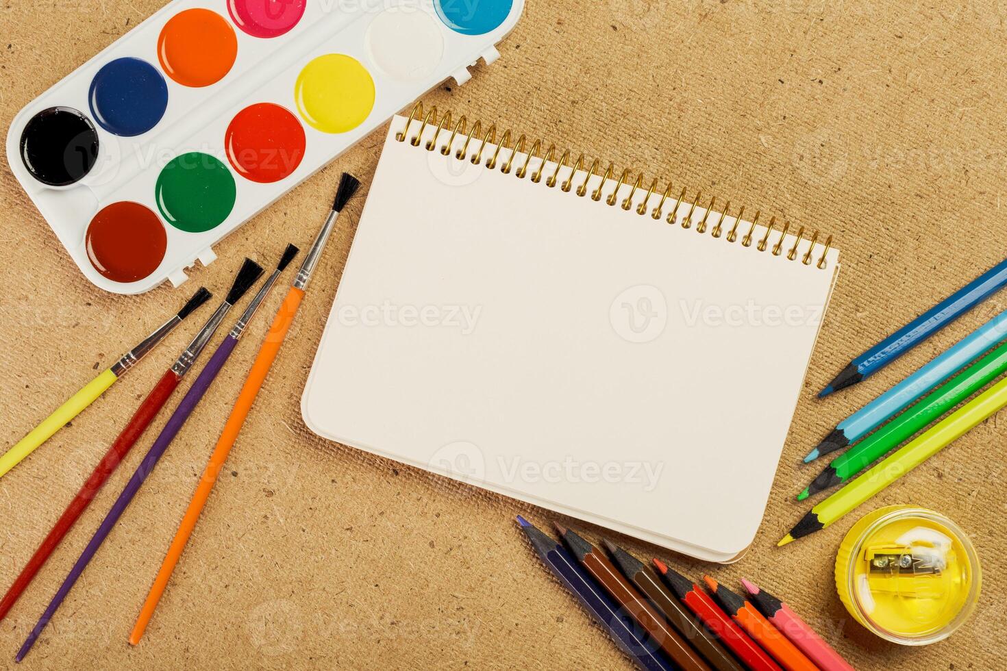 Creative workspace with painting supplies and blank sketchbook ready for artistic expression photo