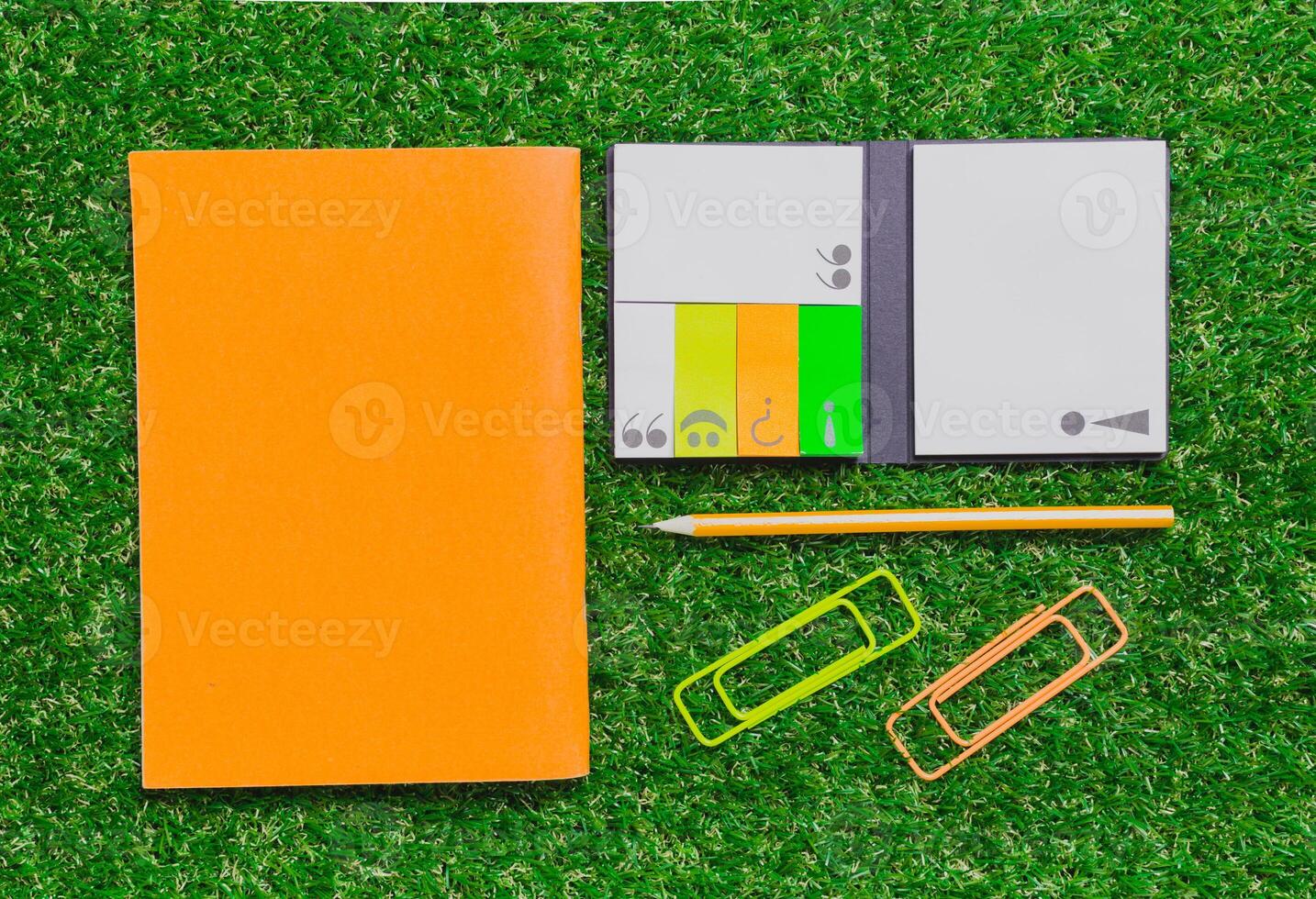Bright desk accessories on green grass create a vibrant and inviting workspace environment photo