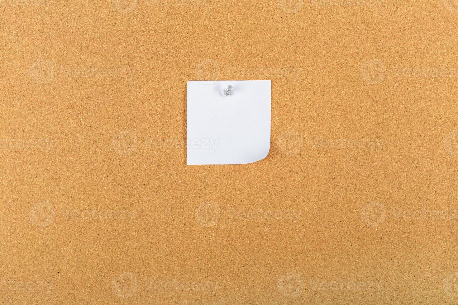 Small white paper note pinned to a corkboard in an office or classroom setting during daytime photo