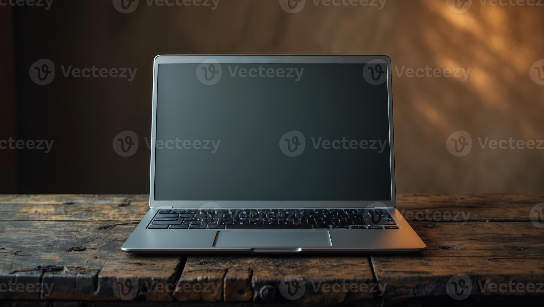 Laptop on an old wooden table in a warm, softly lit room with natural textures and shadows creating a cozy atmosphere photo