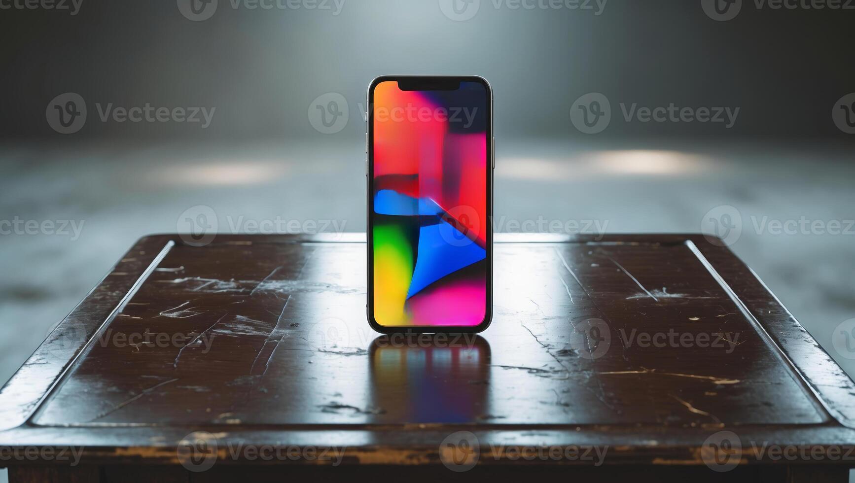 Colorful smartphone display showcased on wooden table in a dimly lit room photo