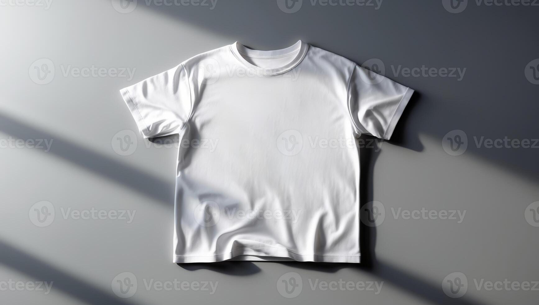 Minimalist white t-shirt displayed on a gray surface with soft shadows during afternoon light photo