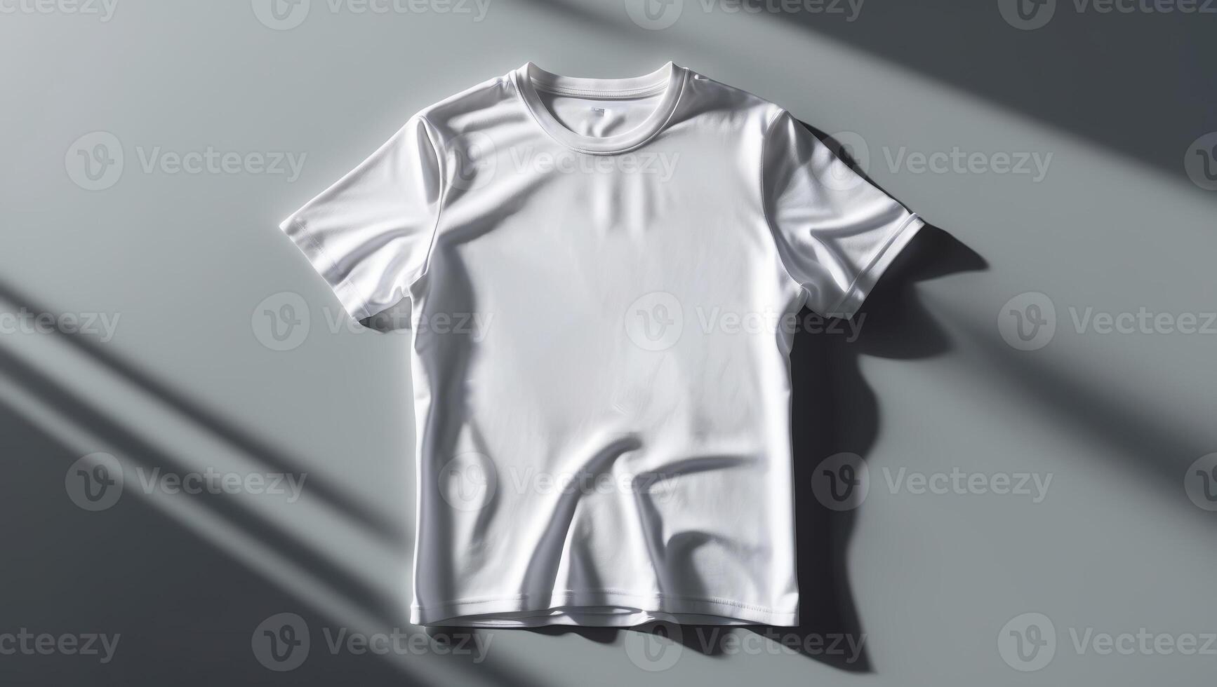 Clean white shirt displayed on a grey surface with shadows highlighting its texture and folds in natural light photo
