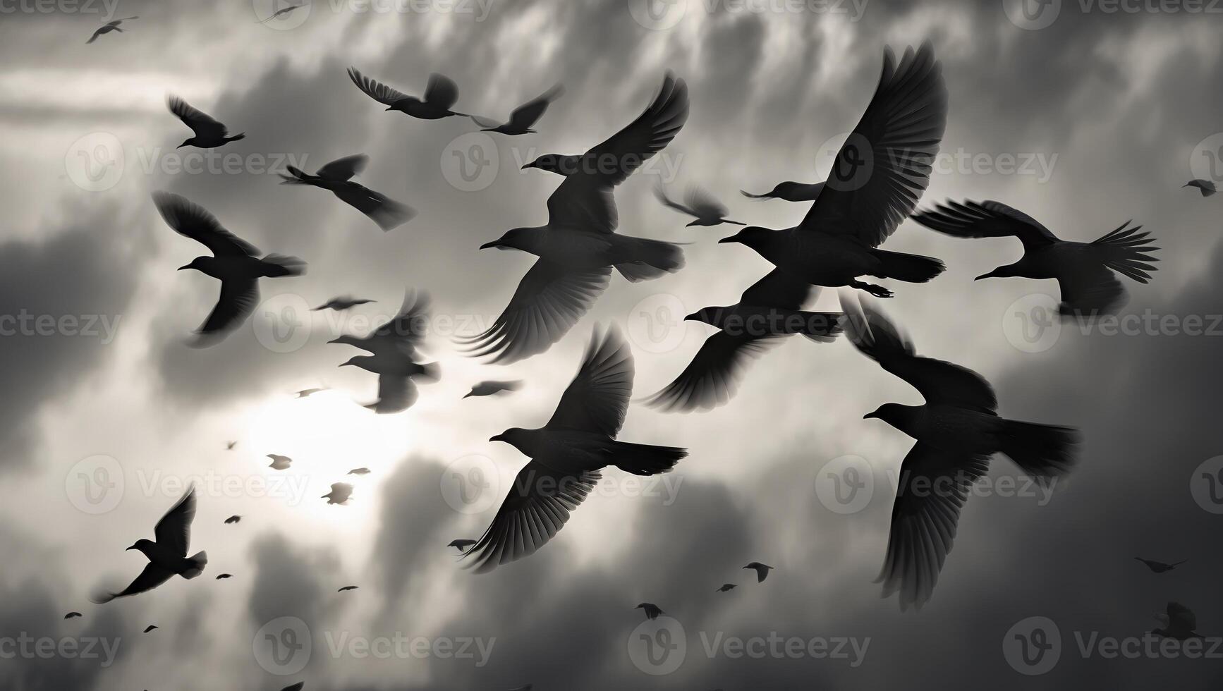 Birds flying through a cloudy sky at dusk, creating a dramatic silhouette against the fading light photo