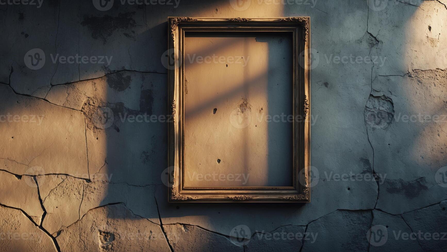 Old, cracked wall with an ornate empty frame illuminated by sunlight in an abandoned setting photo