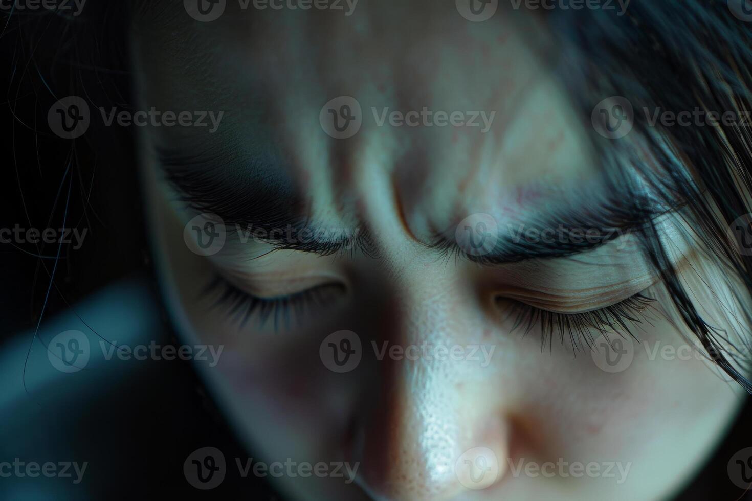 A woman with her eyes closed looking down photo
